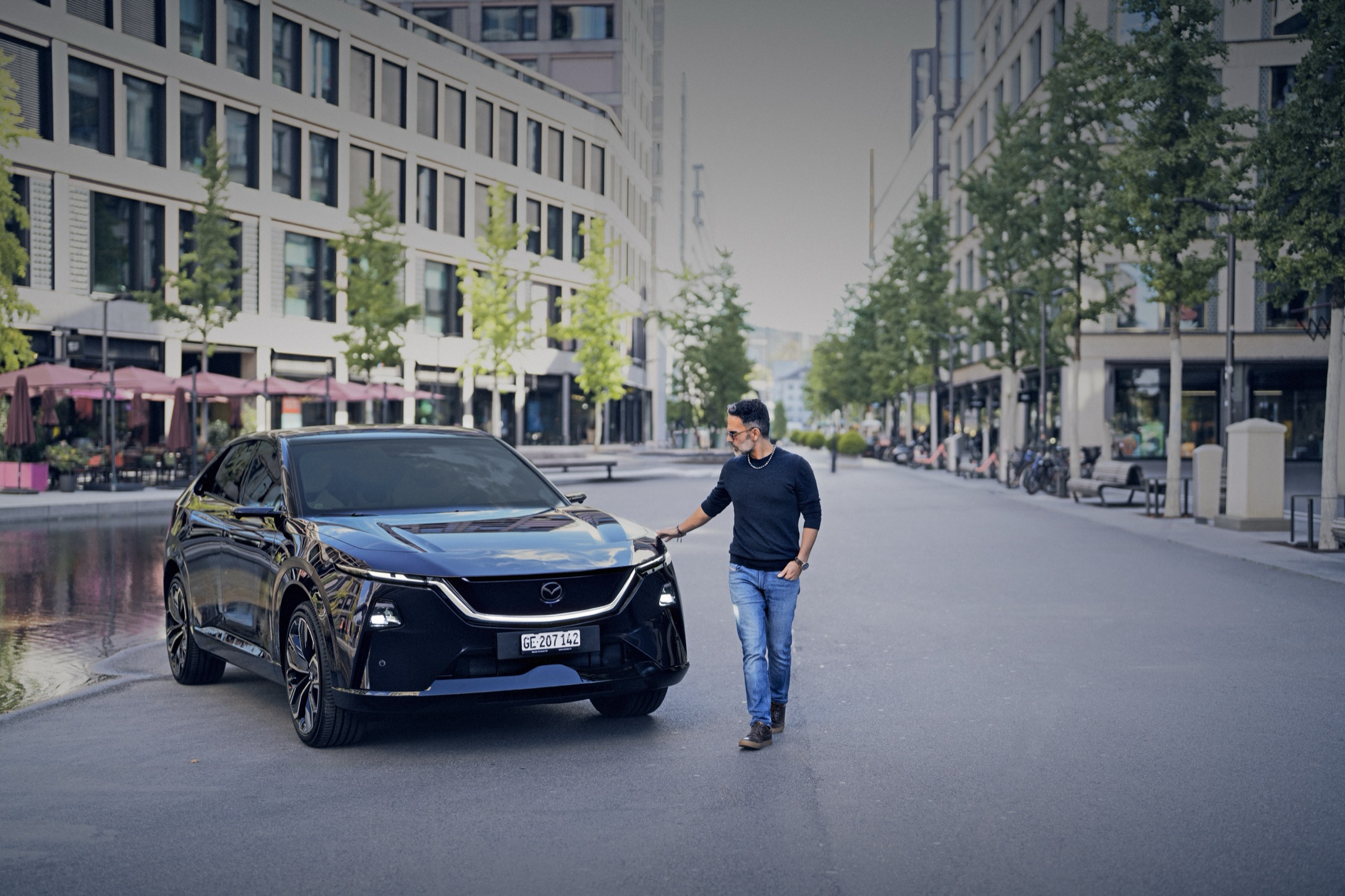 Sahak Demirci geht in Zürich auf den Mazda CX-6e in Nightfall Violet zu