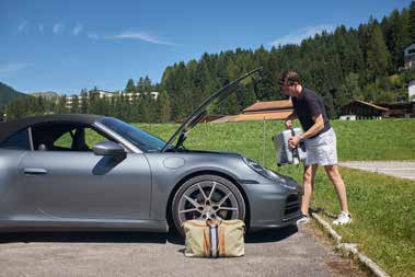 Offene Fronthaube des 911 Carrera T mit Weekender-Tasche vor Davoser Bergwiese